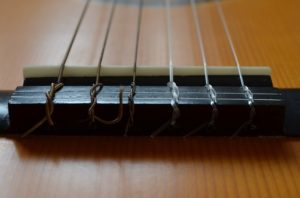 Klassikgitarre, spanische Gitarre, Steg mit Nylonsaiten Steg einer Klassikgitarre mit Nylonsaiten